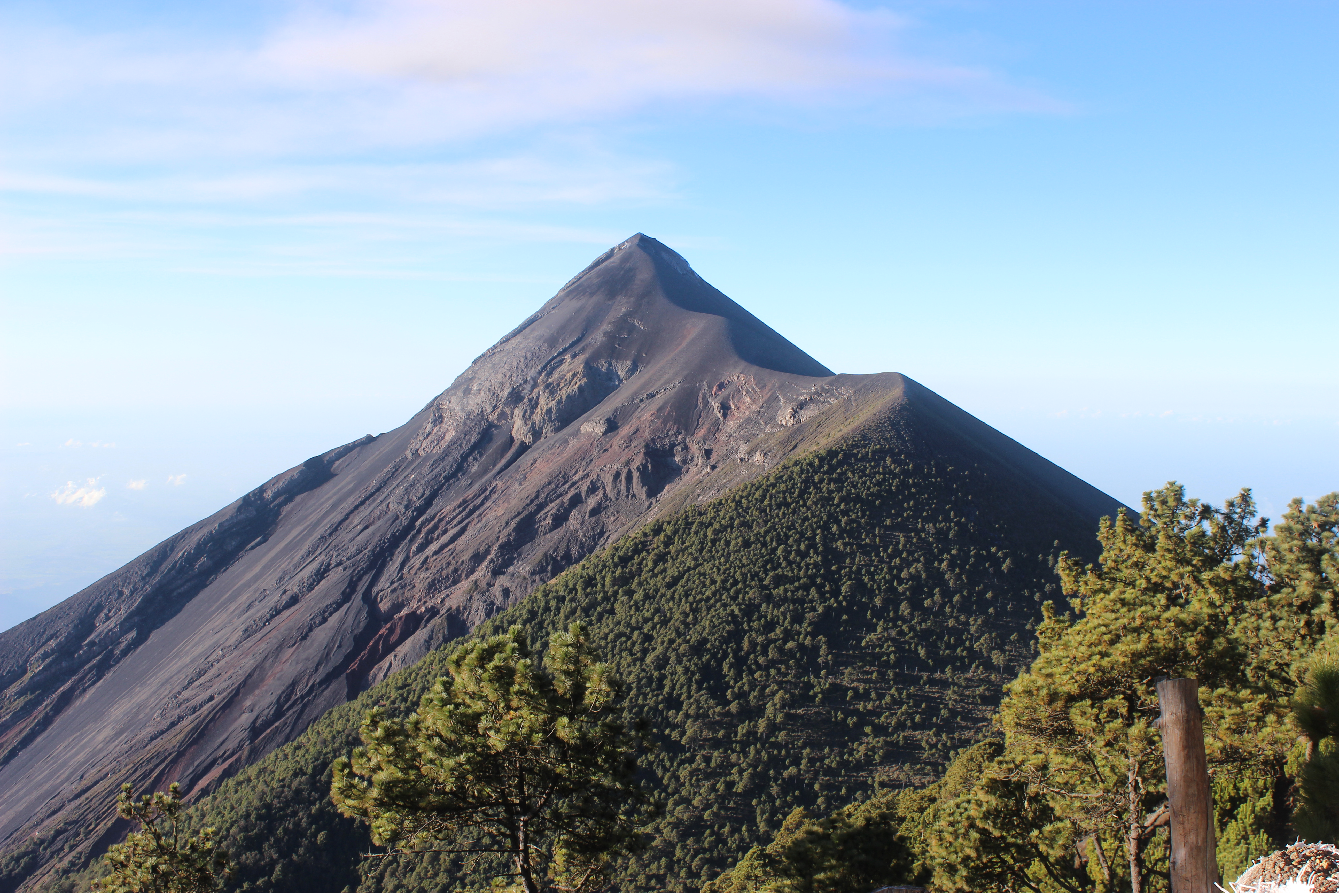 Fuego Volcano in Guatemala in front of a pale blue sky.