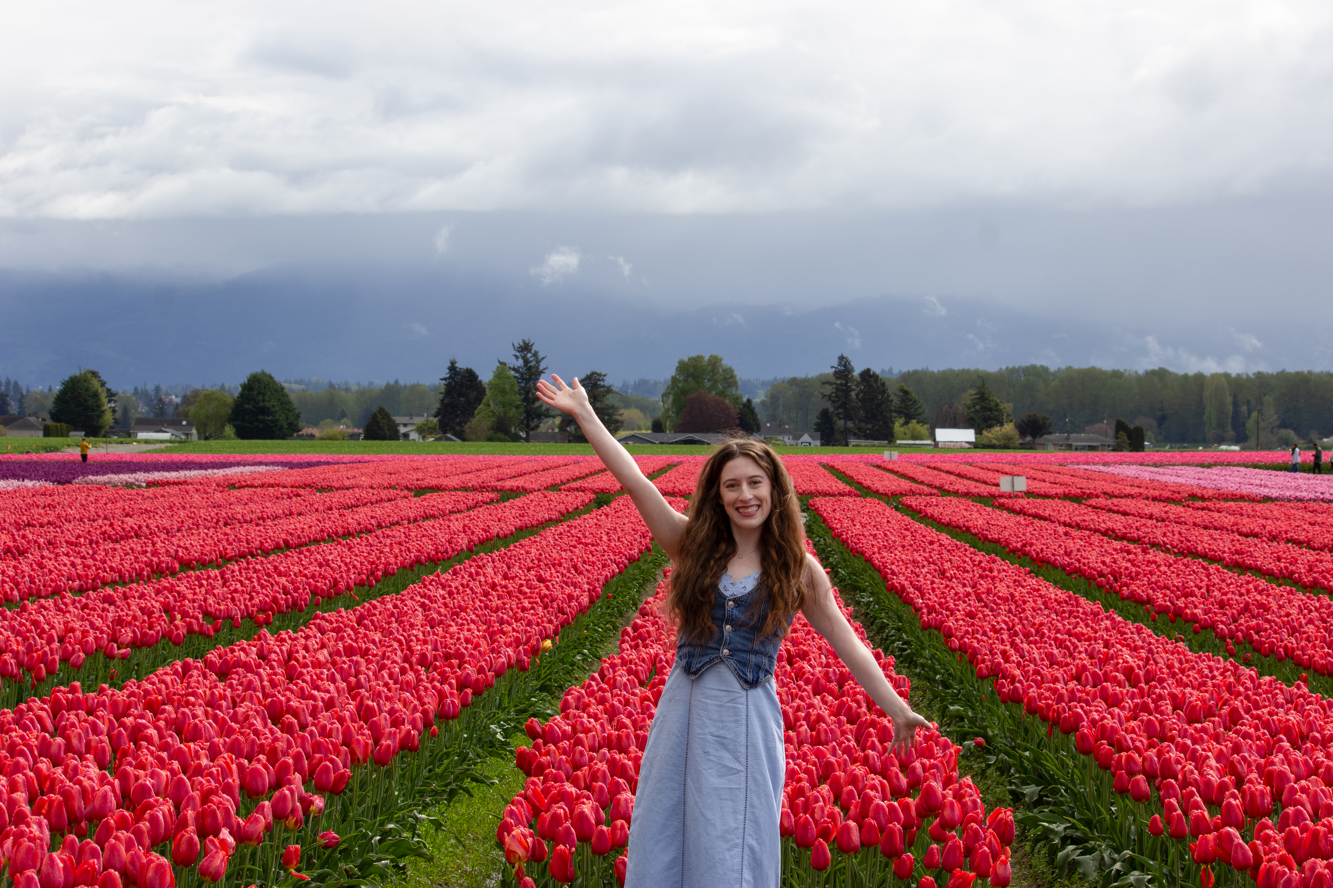 Bella posing in front of vibrant red tulips at RoozenGaarde in Mount Vernon, Washington.