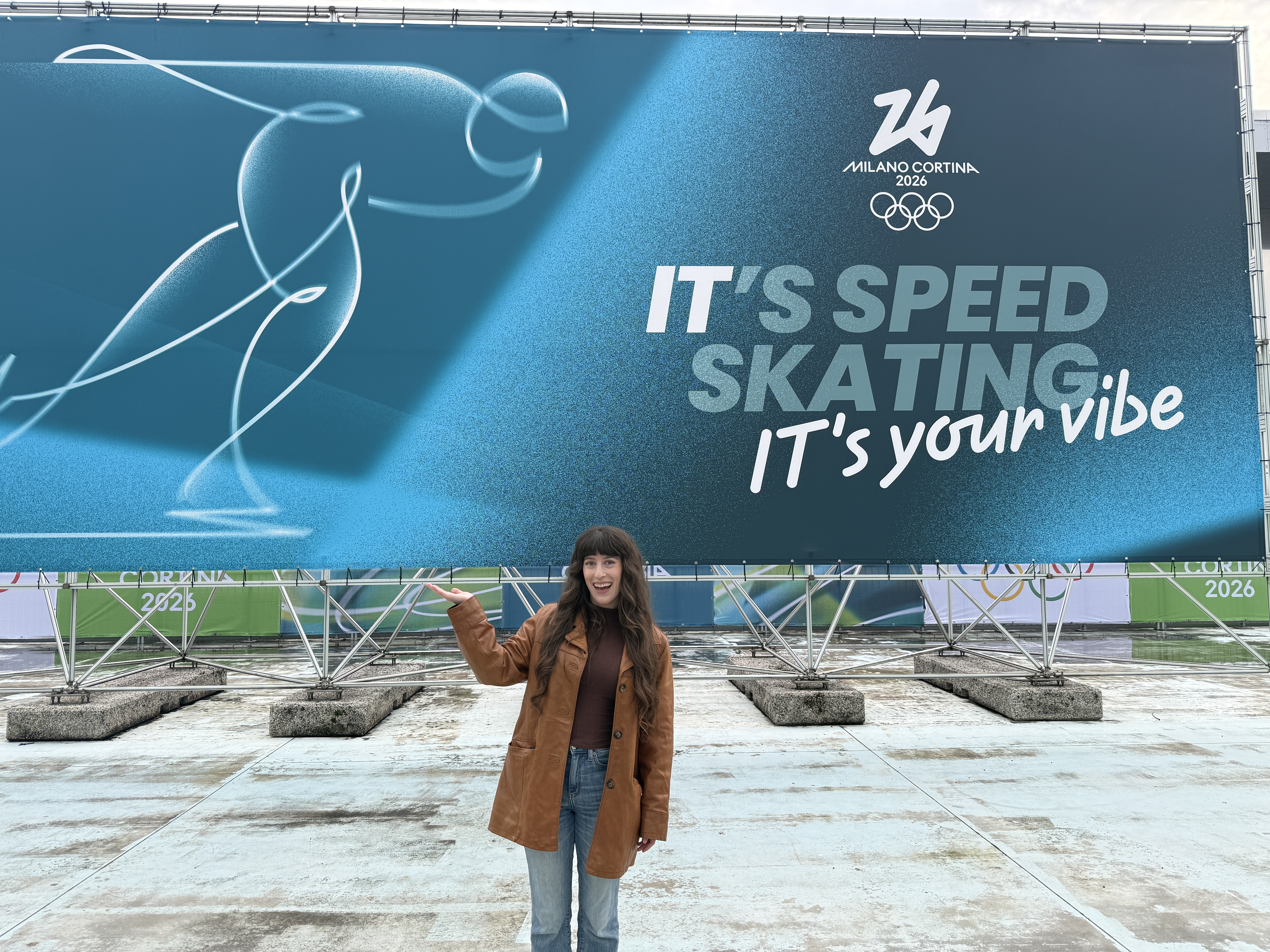 Bella posing in front of the speed skating sign, Milano-Cortina 2026.