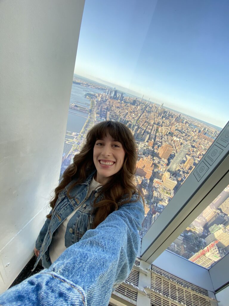 Bella, selfie at the top of One World Observatory with the NYC skyline.