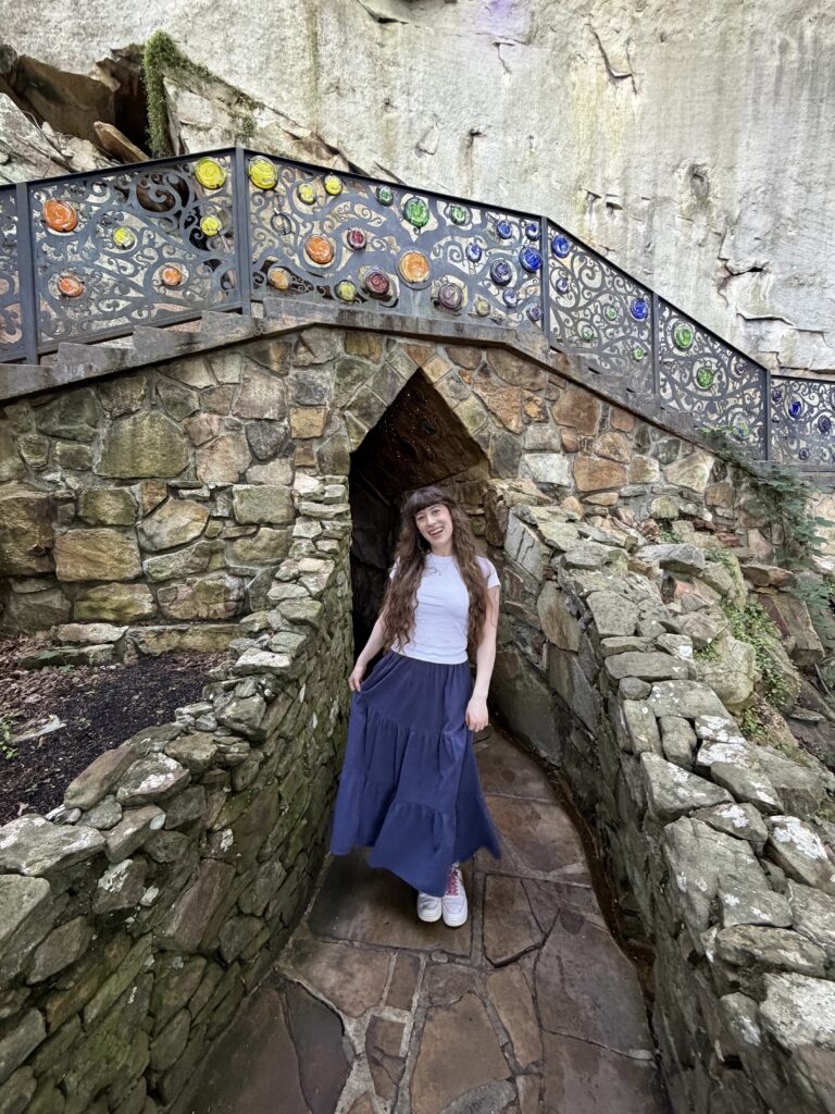 Bella smiling on a scenic rock trail with a decorative railing at Rock City.