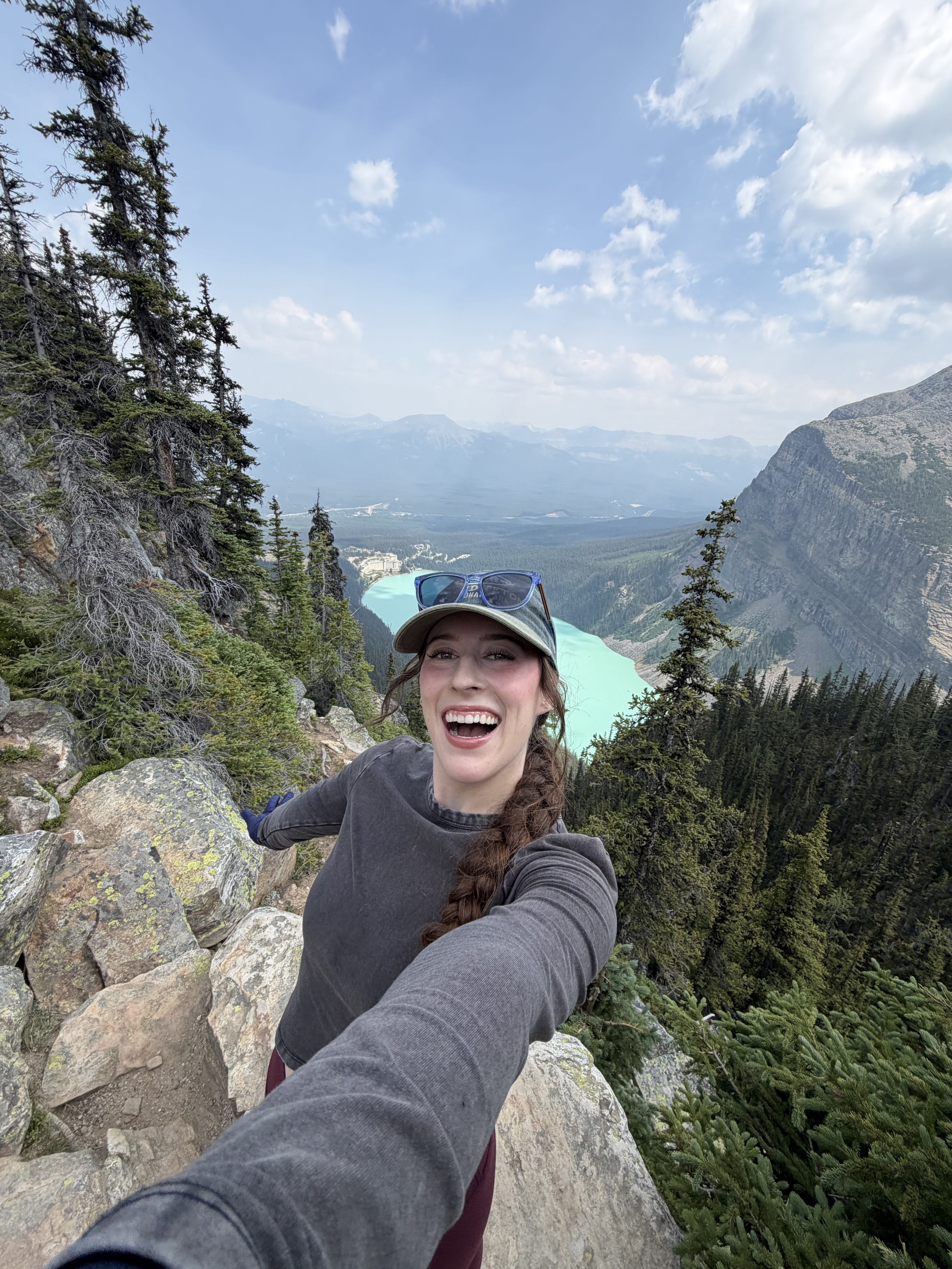 Bella taking a selfie at the top of Big Beehive with view of Lake Louise.