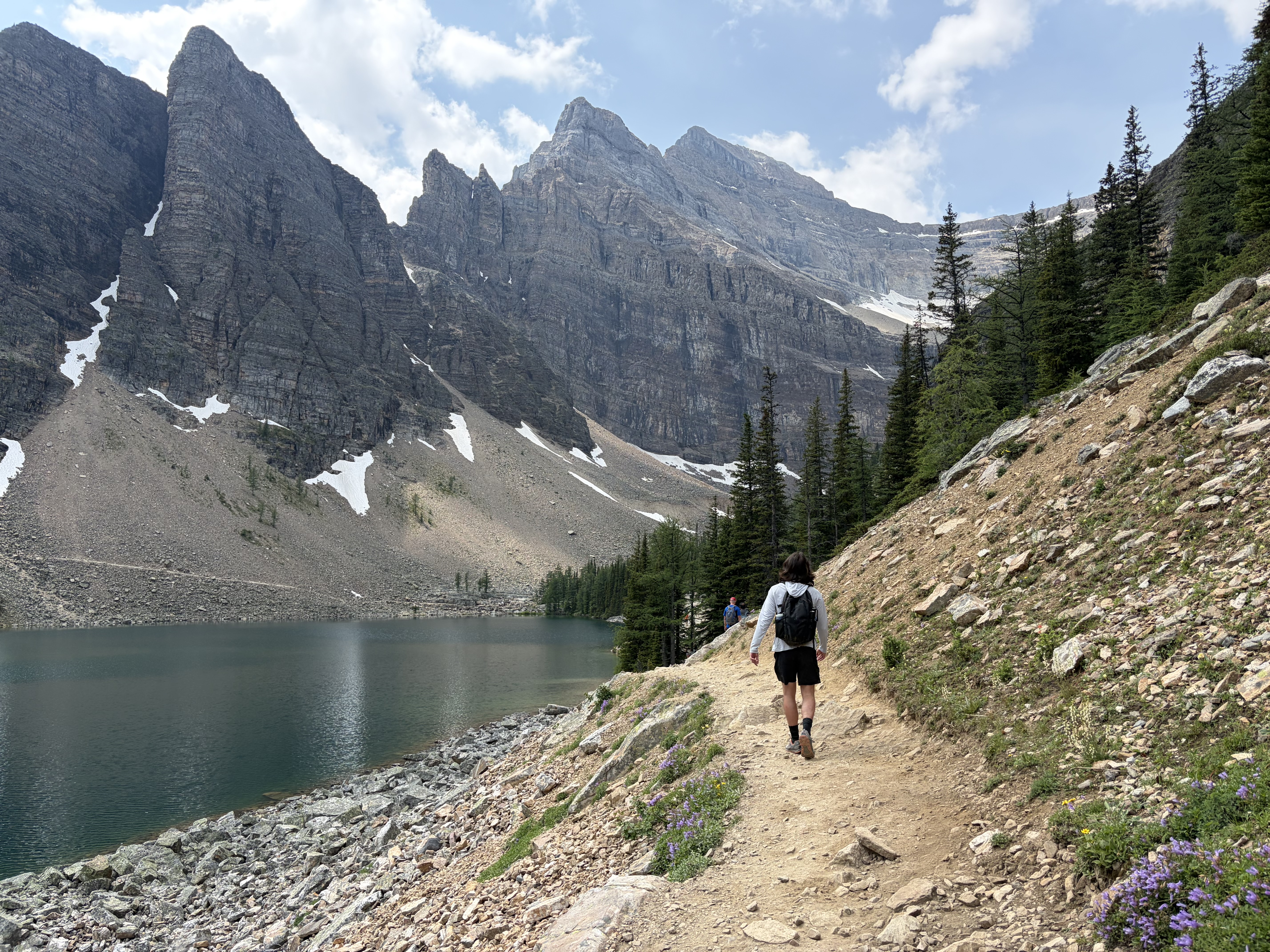 Hiking trail to Big Beehive, Banff National Park, with Lake Agnes beneath towering, jagged peaks. 
